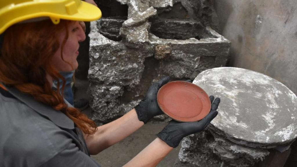 Una de las arqueólogas sostiene el plato de 'terra sigillata'.