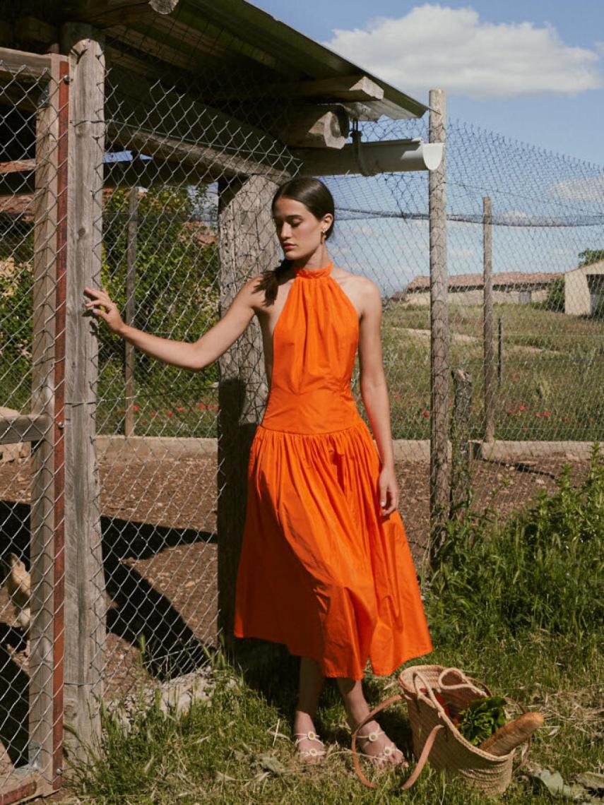 Vestido en el color de moda de este verano, el naranja intenso. A la venta por 227 euros.