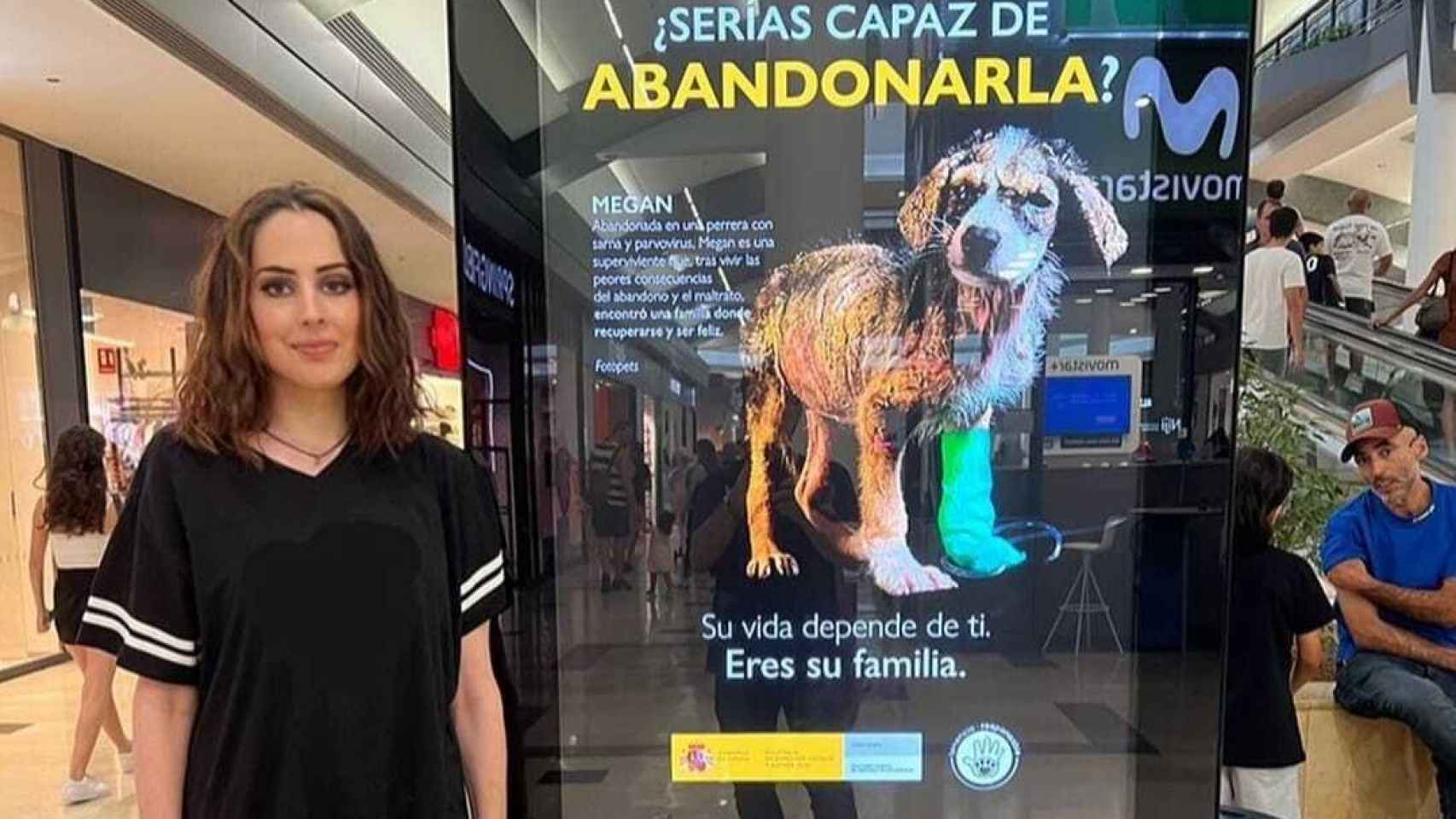 Núria Querol posa junto a un cartel de una campaña de protección animal.