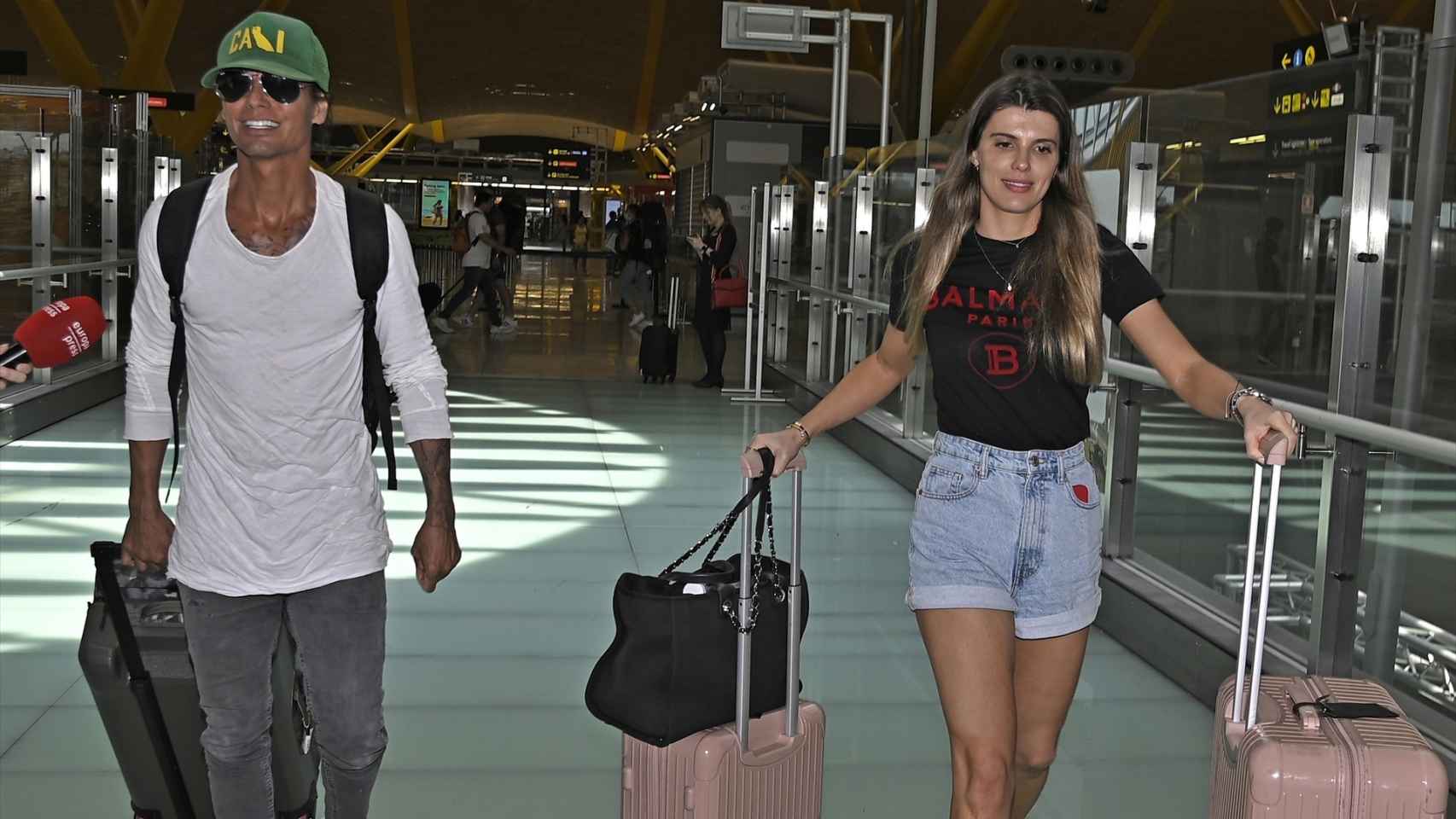 Julio Iglesias junto a su 'amiga especial' en el aeropuerto de Madrid.