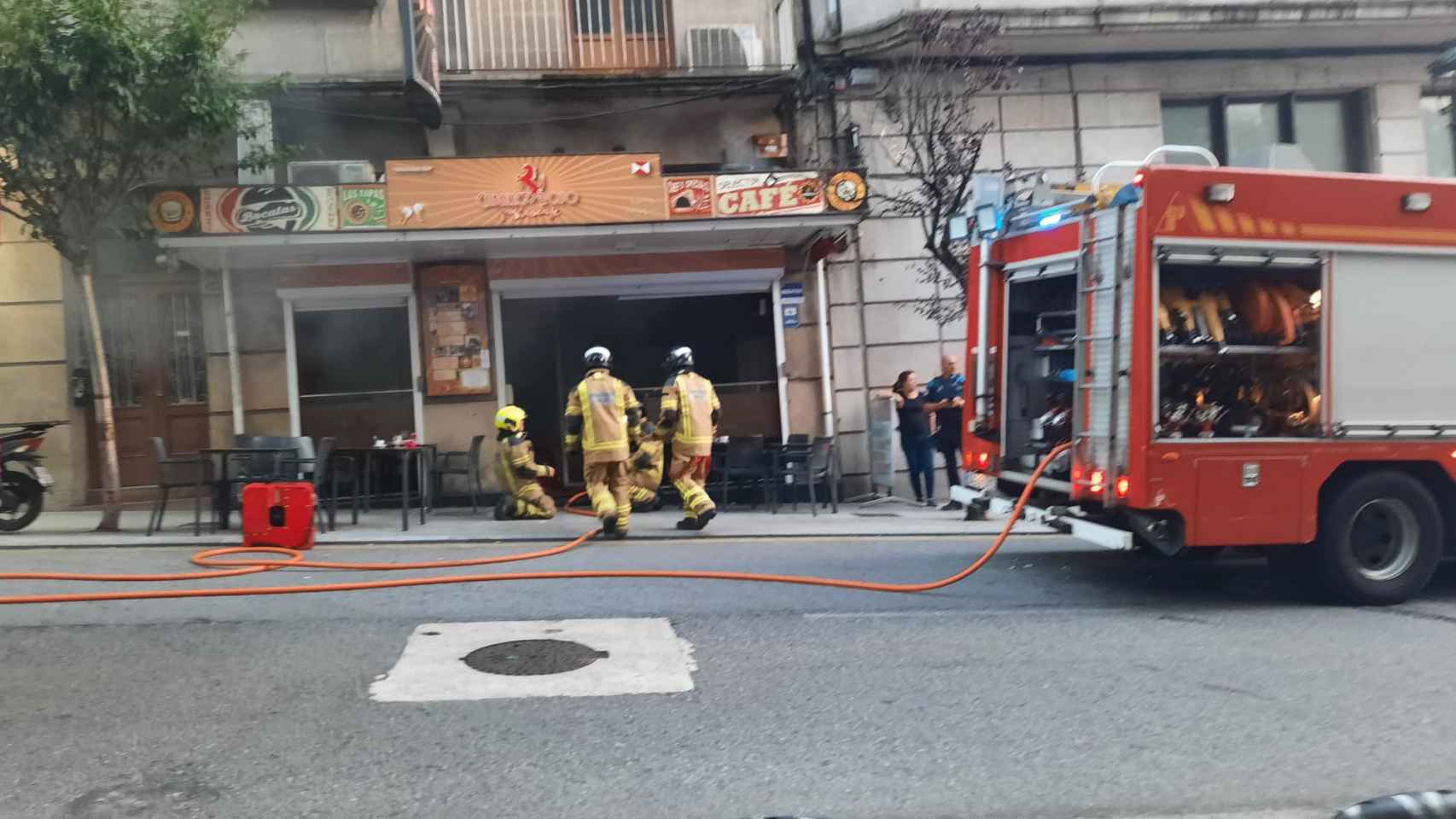Bomberos de Vigo sofocan las llamas en la cafetería Caballo Rojo.