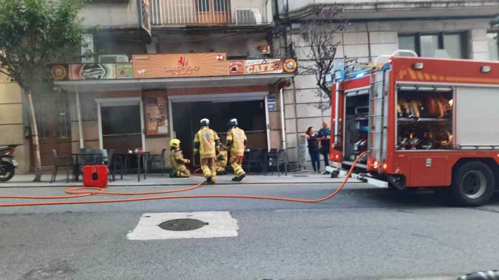 Bomberos de Vigo sofocan las llamas en la cafetería Caballo Rojo.