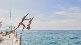 Imagen de archivo dos chicas saltando desde un barco.