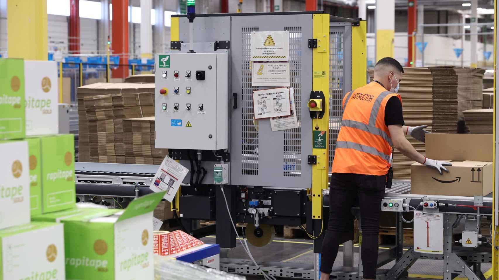 Un trabajador prepara un pedido, en una caja de cartón, en las instalaciones del Centro Logístico de Amazon en Alcalá de Henares, Madrid (España).