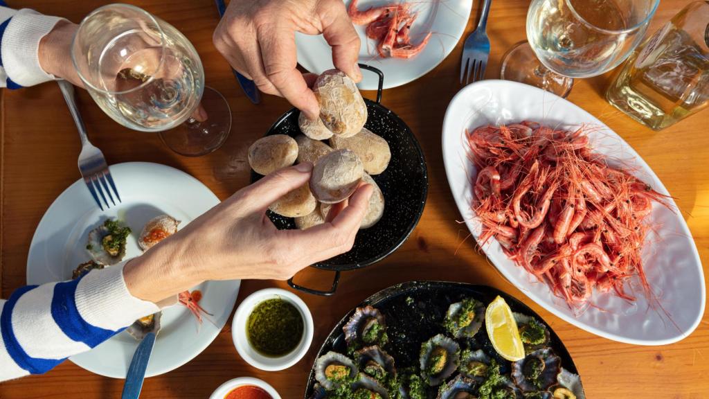 Camarones, lapas y papas con vino blanco en Tajao.