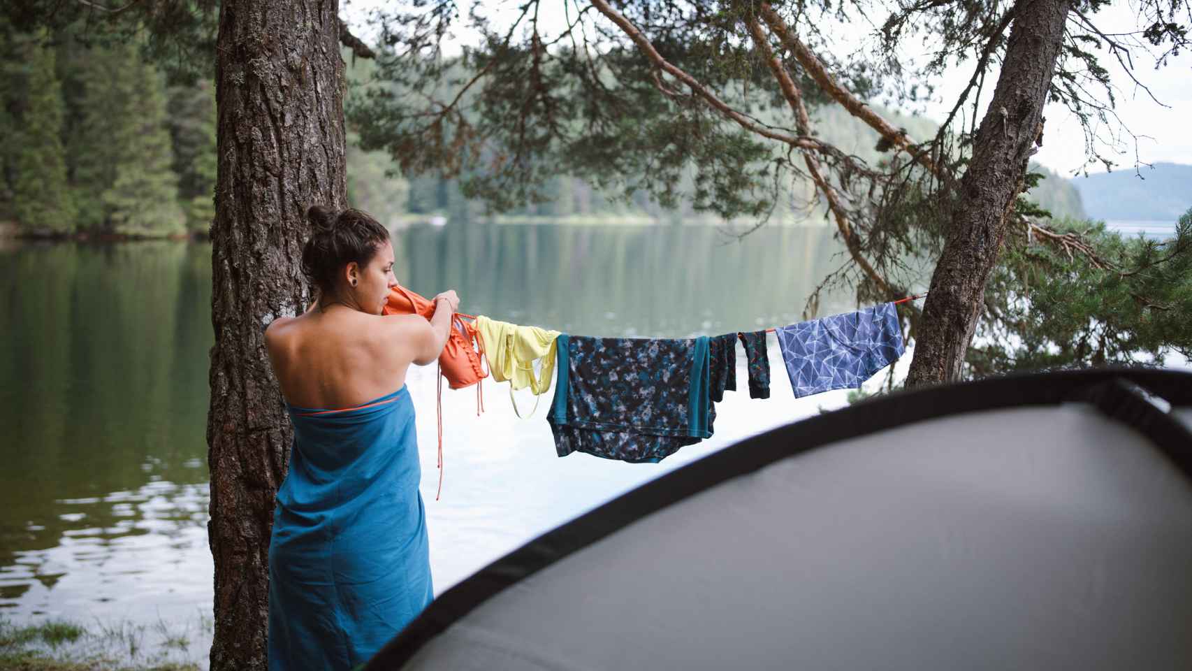 Mujer tendiendo su ropa en un camping
