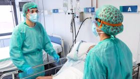 Dos sanitarios se encargan de un paciente con covid