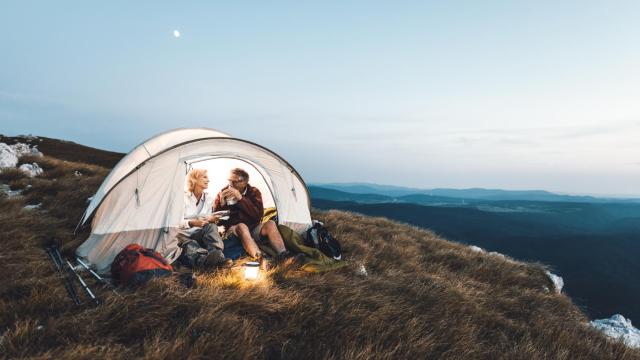 Pareja acampando en la montaña junto al mar