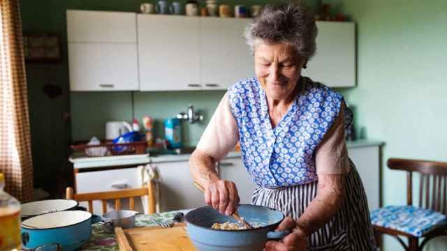 Imagen de archivo de una mujer mayor cocinando. iStock