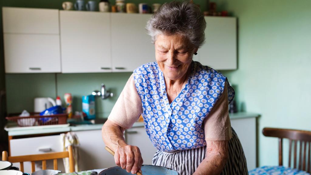 Imagen de archivo de una mujer mayor cocinando.