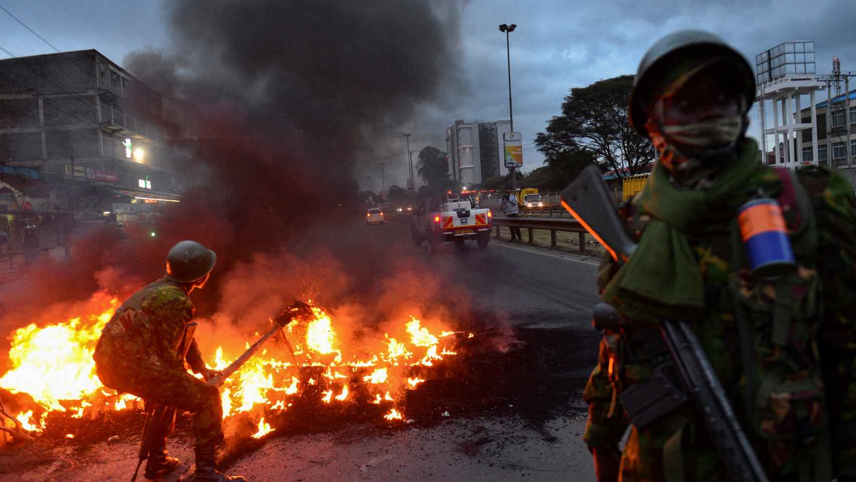 Oficiales de policía intentan apagar una barricada, en Nairobi.