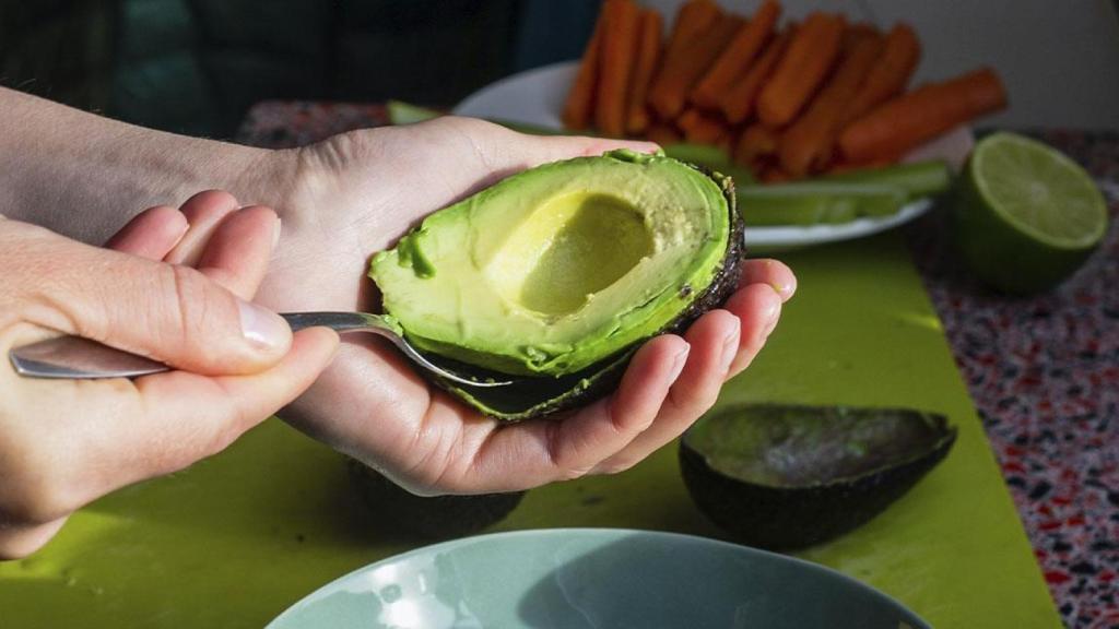 Unas personas comiendo aguacate.