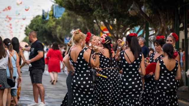 Un grupo de mujeres, vestidas de flamenca en el recinto ferial de Málaga.
