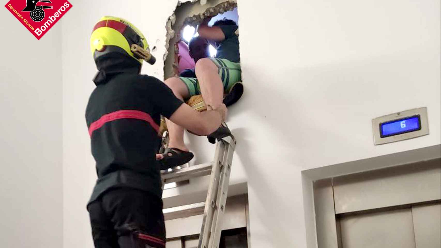 Un bombero saca a uno de los jóvenes atrapados dentro del ascensor en Benidorm.