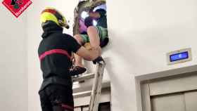 Un bombero saca a uno de los jóvenes atrapados dentro del ascensor en Benidorm.