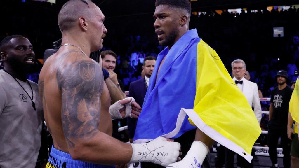 Oleksandr Usyk y Anthony Joshua, con la bandera de Ucrania tras su combate en 2022