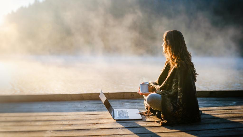 Una mujer relajada escribe al aire libre.