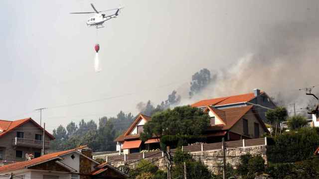 Un helicóptero participa en las labores de extinción del incendio declarado en Meira, Moaña (Pontevedra).