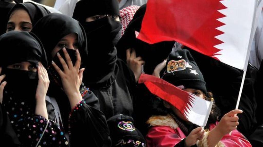 Mujeres de Qatar con banderas del país