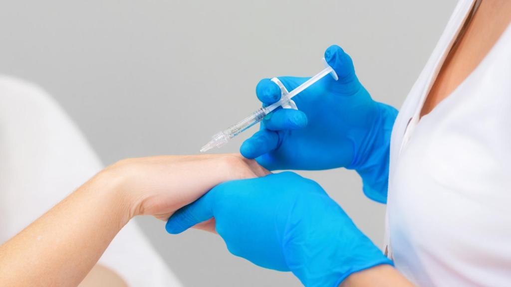 Un cosmetólogo profesional hace una inyección en la mano de una mujer.