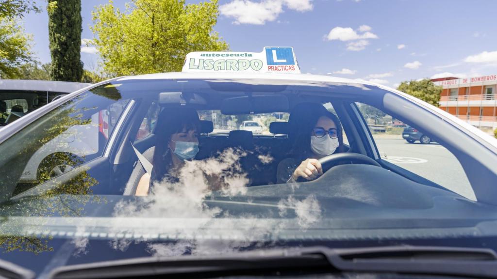 Una alumna de autoescuela realizando prácticas de conducir junto con su profesora