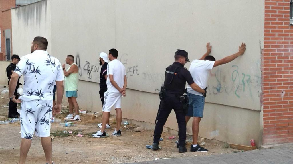 Un policía nacional, este viernes, cacheando a uno de los vecinos del Barrio de San José Obrero para comprobar si porta estupefacientes.