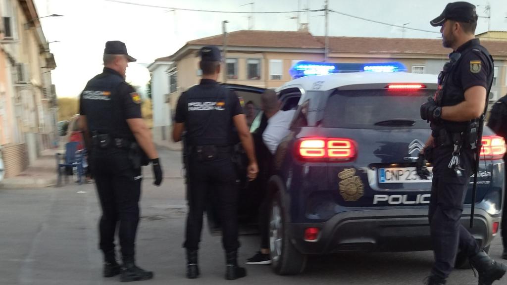 Unos agentes introduciendo en un Zeta a un detenido durante la redada.