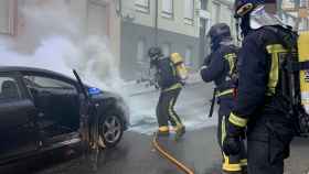 Los agentes tratan de sofocar el fuego en el vehículo incendiado en León