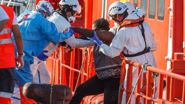 Agentes de salvamento marítimo ayudan a una mujer migrante en Arguineguín (Gran Canaria).