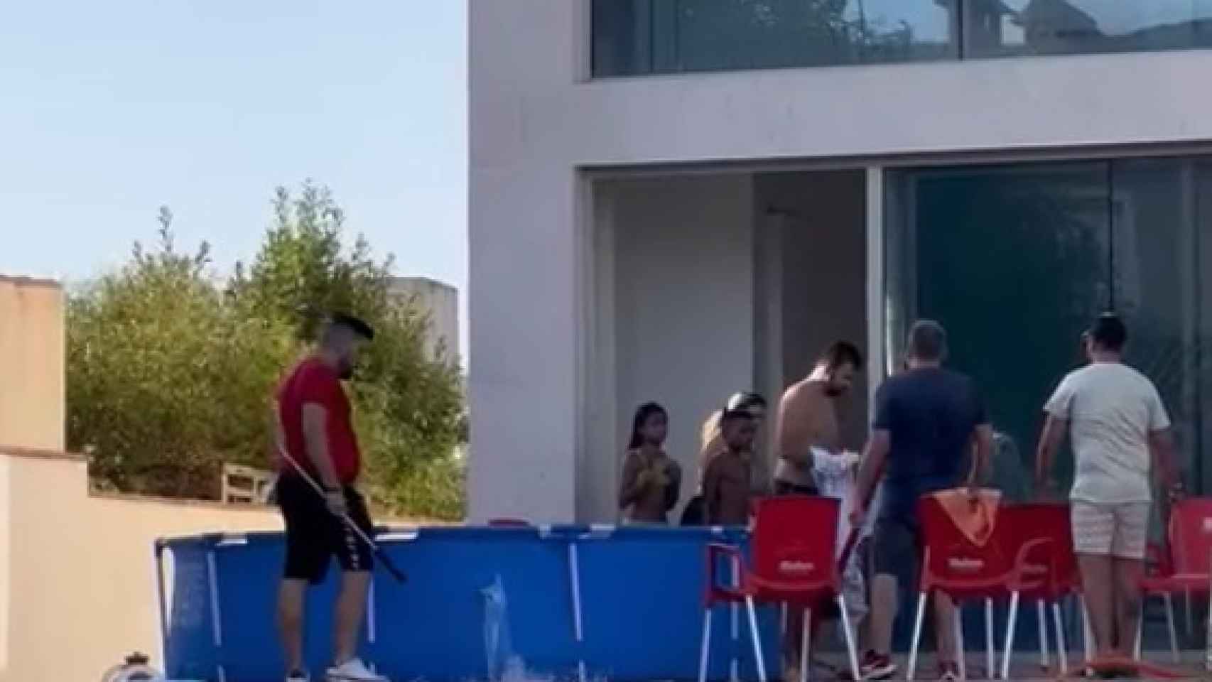 Uno de los instantes del vídeo 'desokupando tu casa' en el que se aprecia cómo han abierto, con una barra metálica, un boquete en la piscina de plástico para asustar a los okupas.