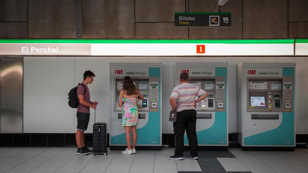 Unos jóvenes frente a la máquina del Metro de Málaga.