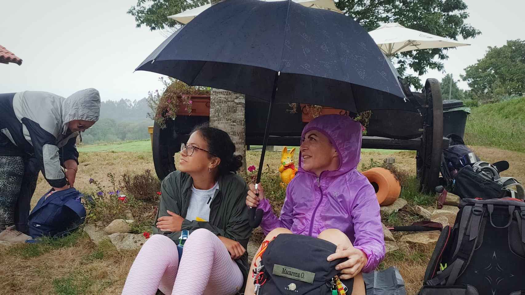 Macarena Olona y su amiga Laura se resguardan de la lluvia en una parada del Camino.