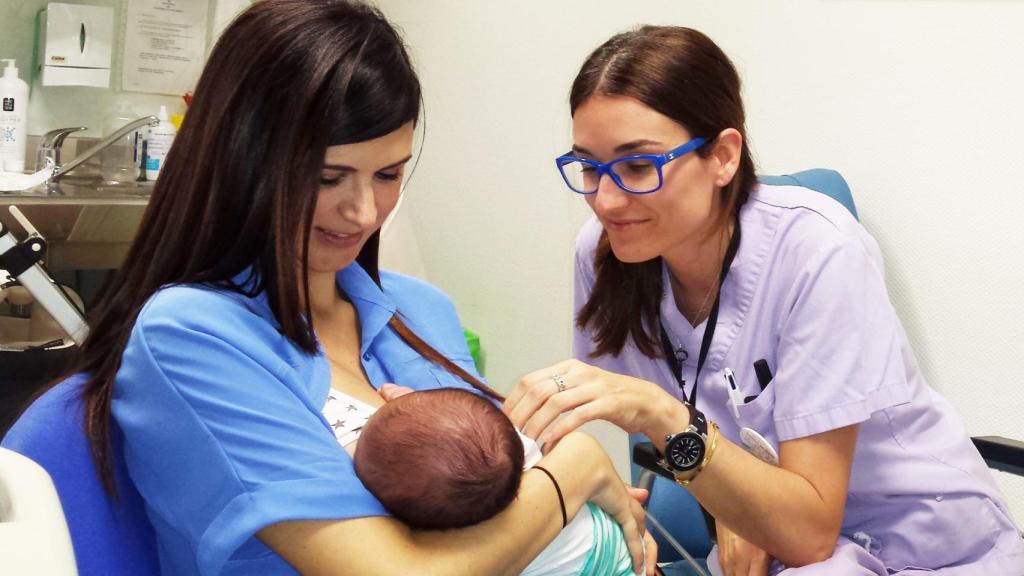 Una sanitaria ayuda a una madre a dar de mamar a su recién nacido.