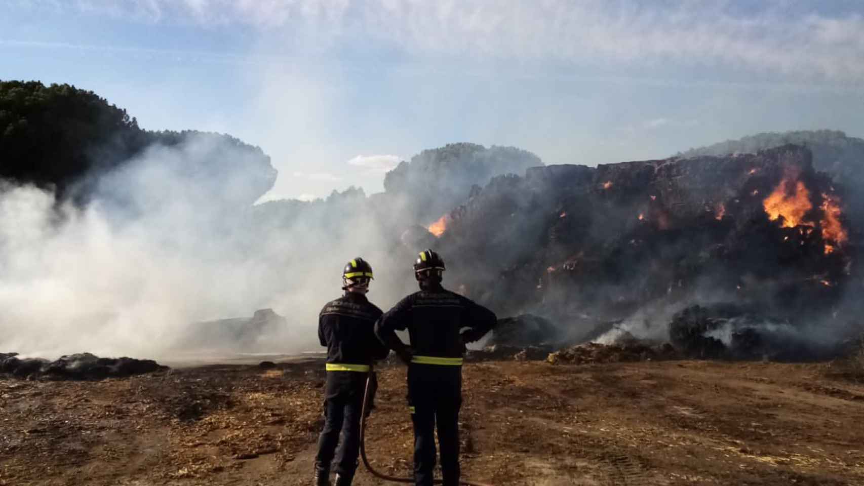 Los bomberos trabajan en las tareas de extinción del incendio de Tudela de Duero, en la tarde de este viernes.