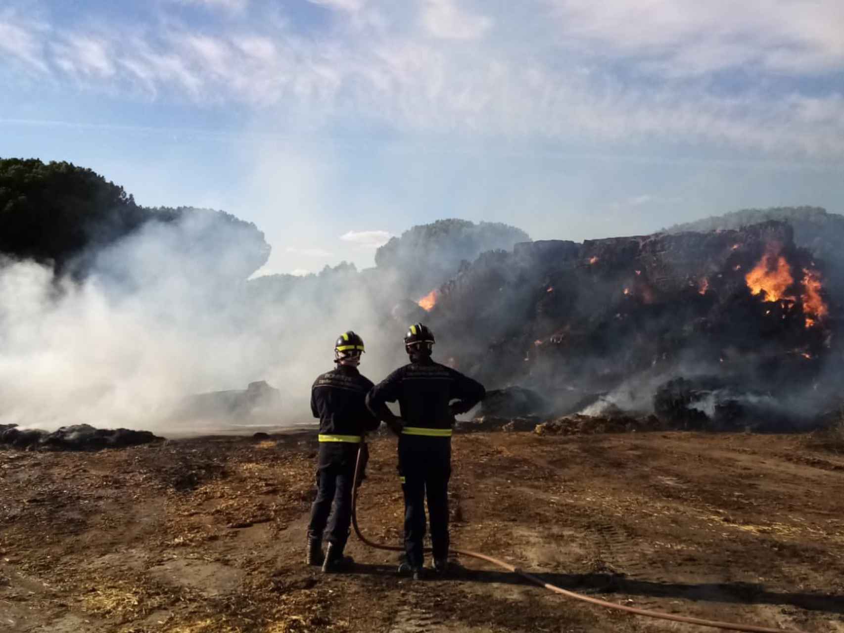 Los bomberos trabajan en las tareas de extinción del incendio de Tudela de Duero, en la tarde de este viernes.