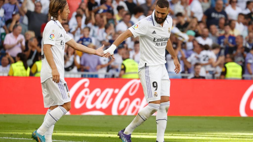 Luka Modric le da la mano a Karim Benzema.