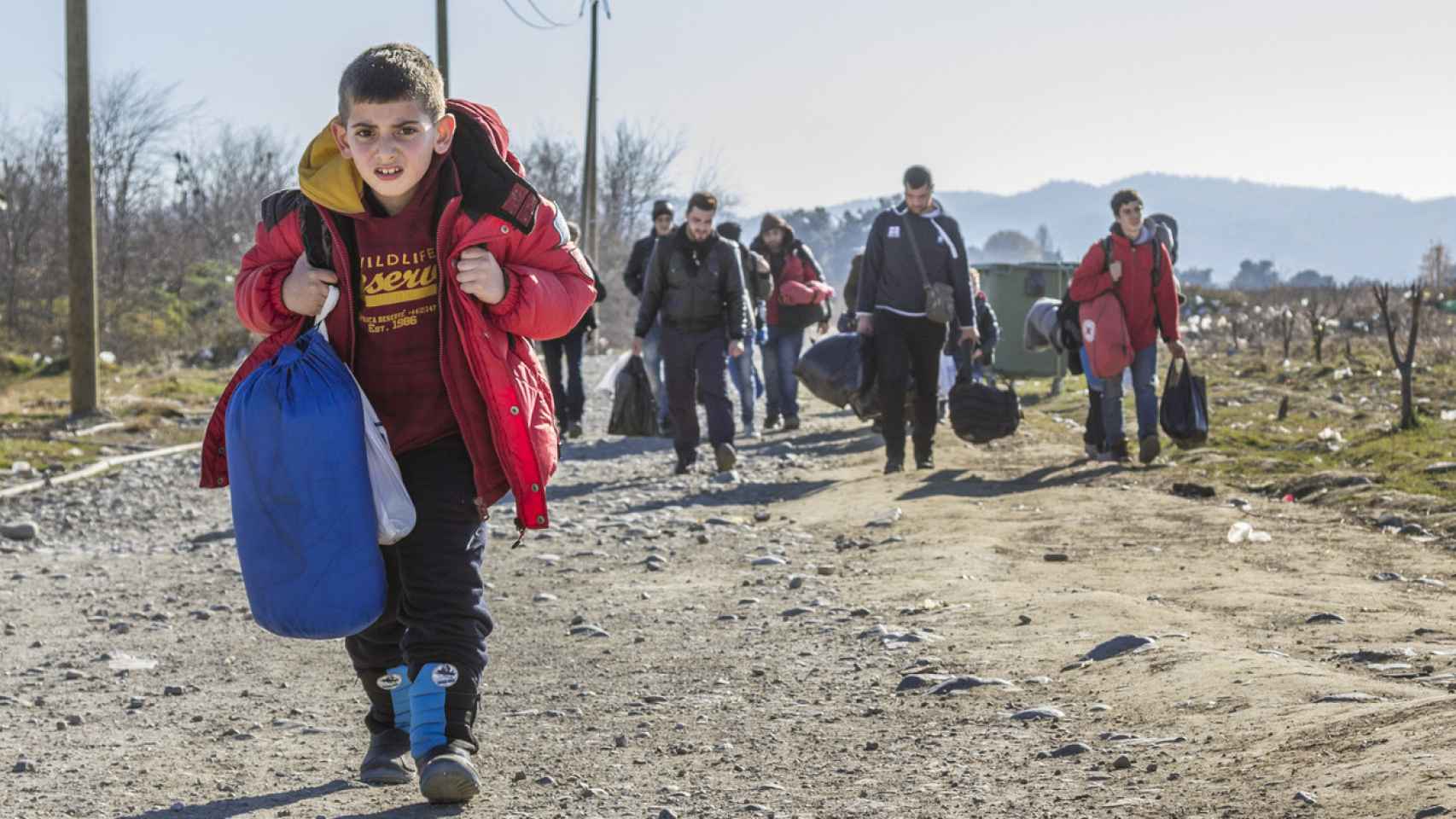 Refugiados cruzando la frontera entre Grecia y Macedonia del Norte.