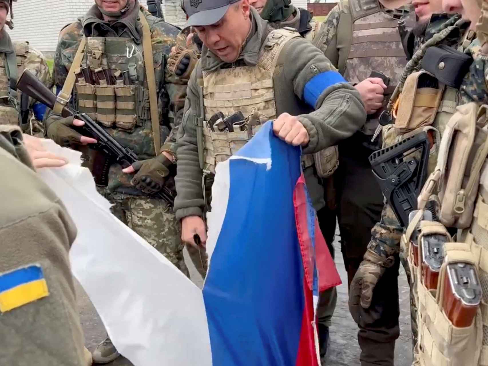 El alcalde de Derhachi, en la región de Járkov, rasga una bandera rusa.