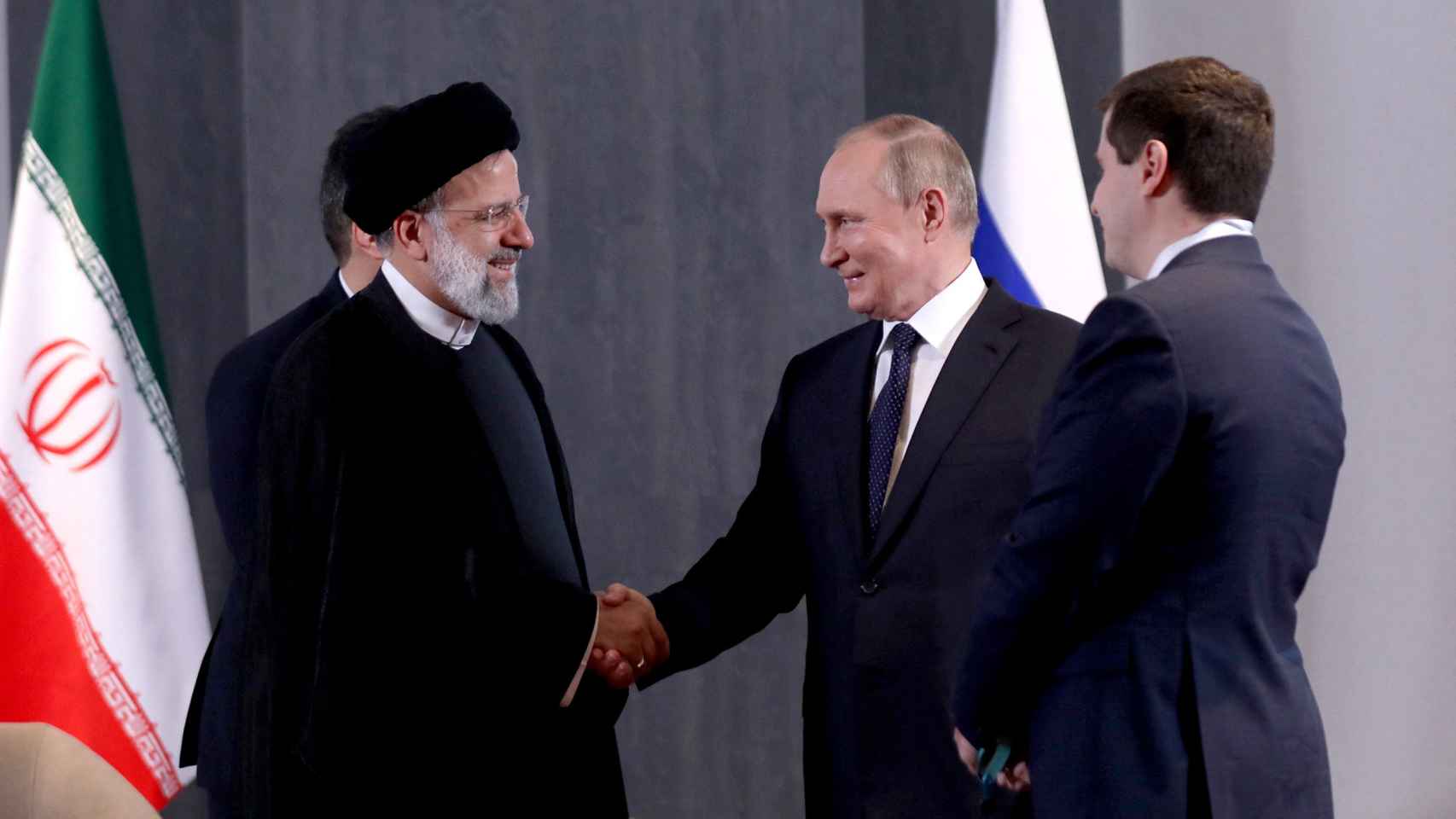 presidente ruso, Vladimir Putin, le da la mano al presidente iraní, Ebrahim Raisi.