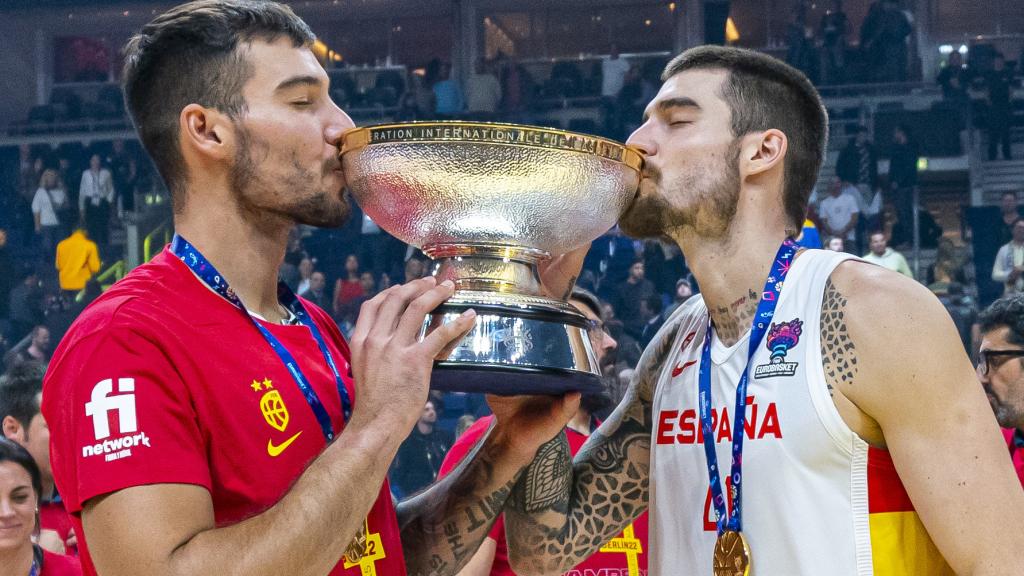 Willy Hernangómez, izquierda, junto a su hermano Juancho, derecha, besando el trofeo del Eurobasket 2022