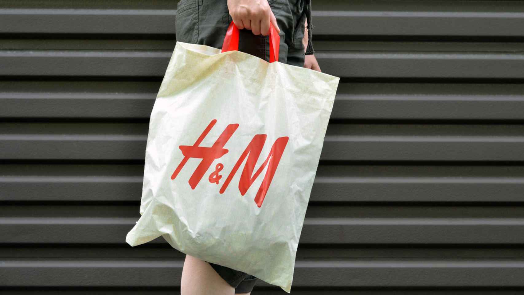 Una mujer con una bolsa de H&M