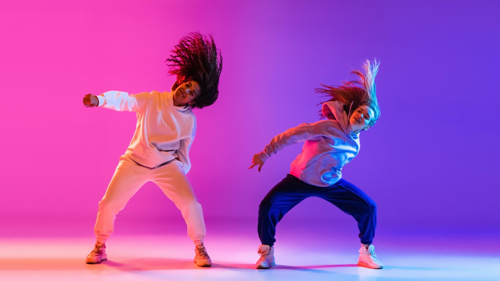 Dos mujeres bailando música urbana.