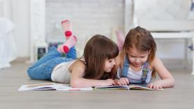 Dos niñas leyendo un cuento.