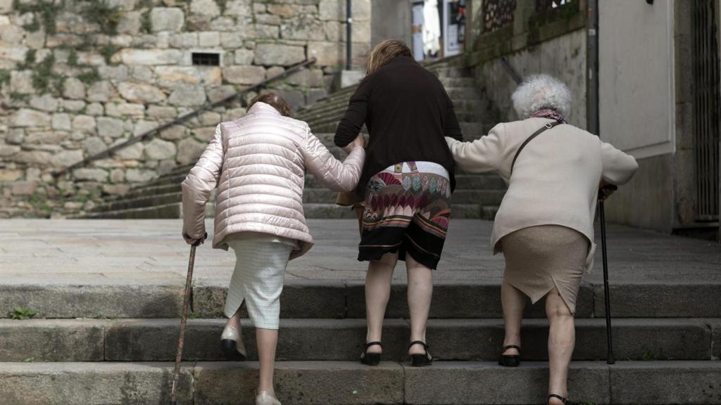 Personas mayores caminan por una calle en Galicia