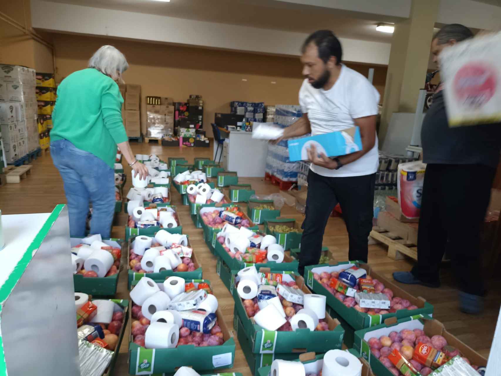 Los voluntarios preparan las cajas con alimentos y material higiénico