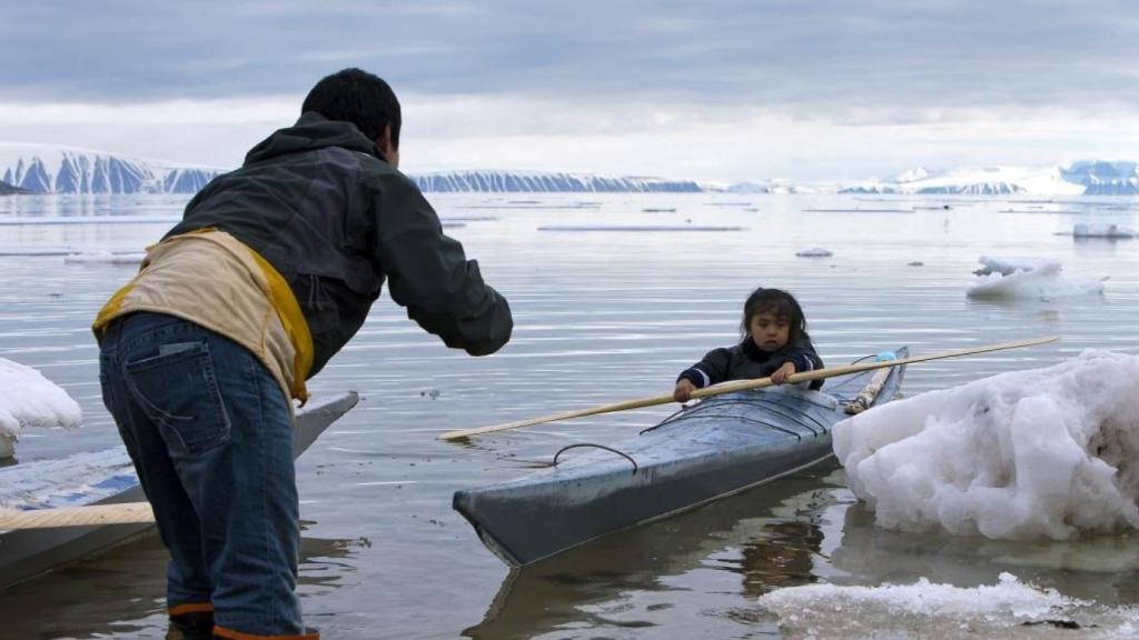 En la foto, un adulto enseña a un niño a remar cerca de Siorapaluk en el noroeste de Groenlandia.