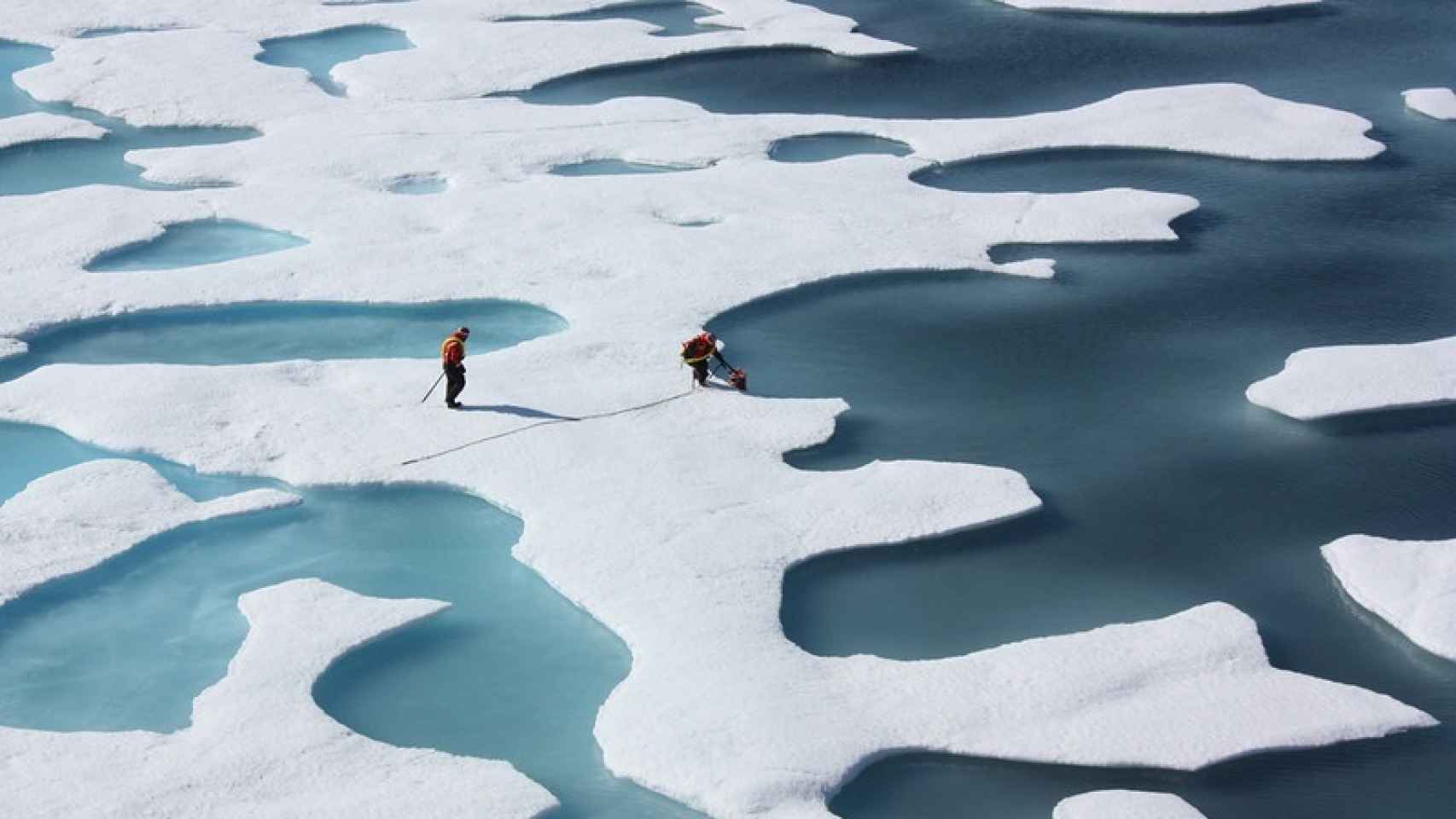 Dos científicos realizando mediciones sobre el espesor del hielo en el Ártico
