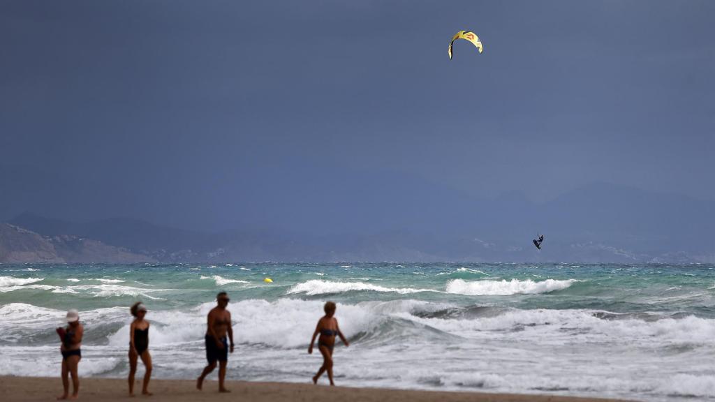 Unos turistas en un aplaya valenciana a mediados de septiembre.