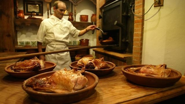 Imagen de un cocinero elaborando lechazos asados