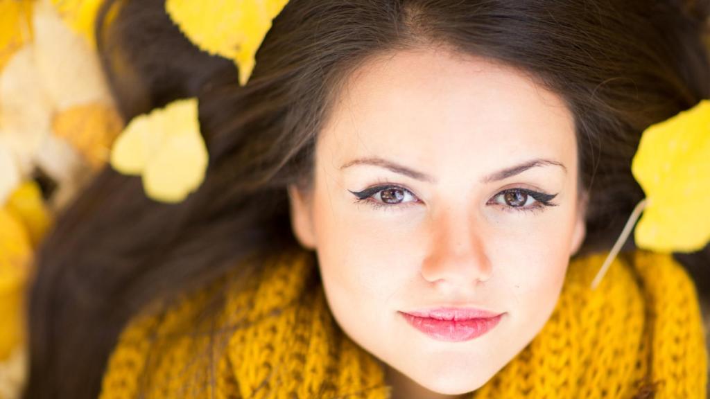 Una chica con hojas de otoño.